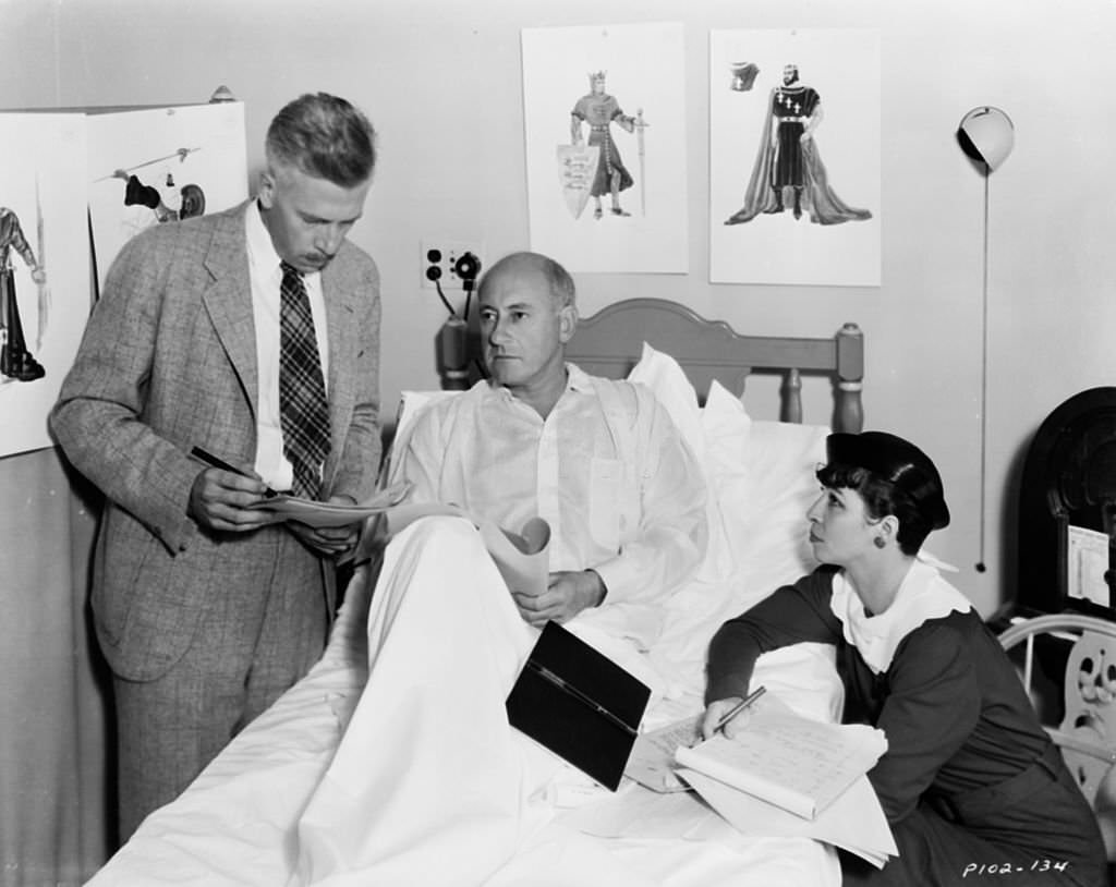 Filmmaker Cecil B DeMille recuperating in bed as his staff discuss the making of the film 'Samson and Delilah' 1949