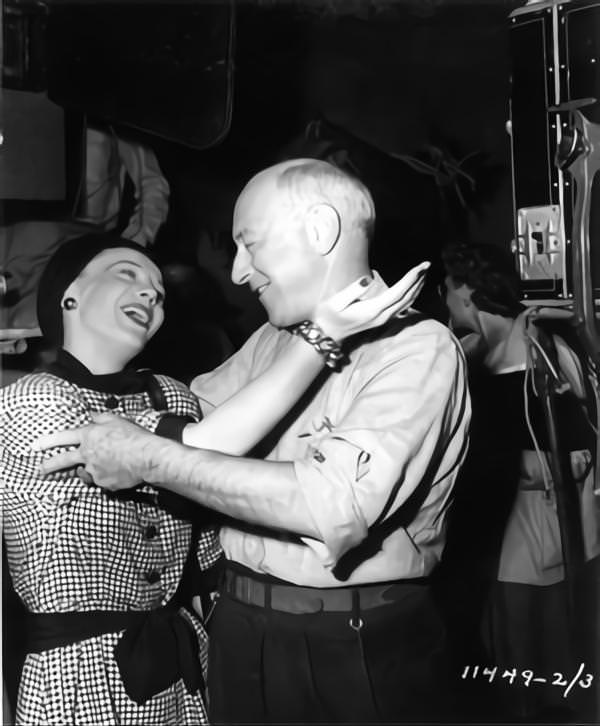 Woman greets Cecil B DeMille on set candid during filming of 'Samson and Delilah', 1949