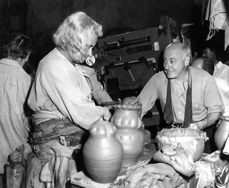 Cecil B DeMille with old extra Woman and Film Crew on set candid during filming of 'Samson and Delilah', 1949