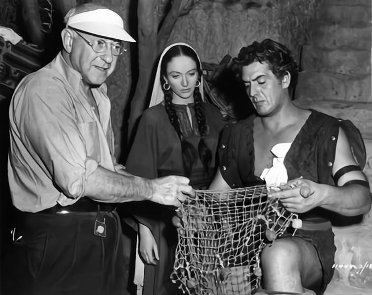 Cecil B DeMille on set candid directing Olive Deering and Victor Mature during filming of 'Samson and Delilah', 1949