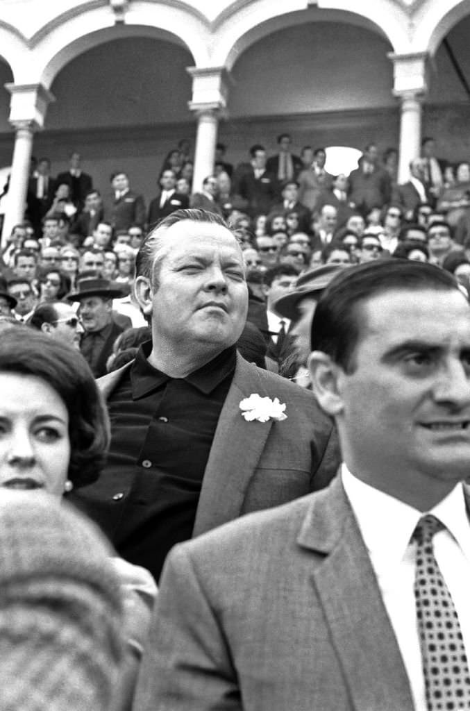 American film director and actor Orson Welles enjoys a bullfight in Seville during the Feria de Abril.