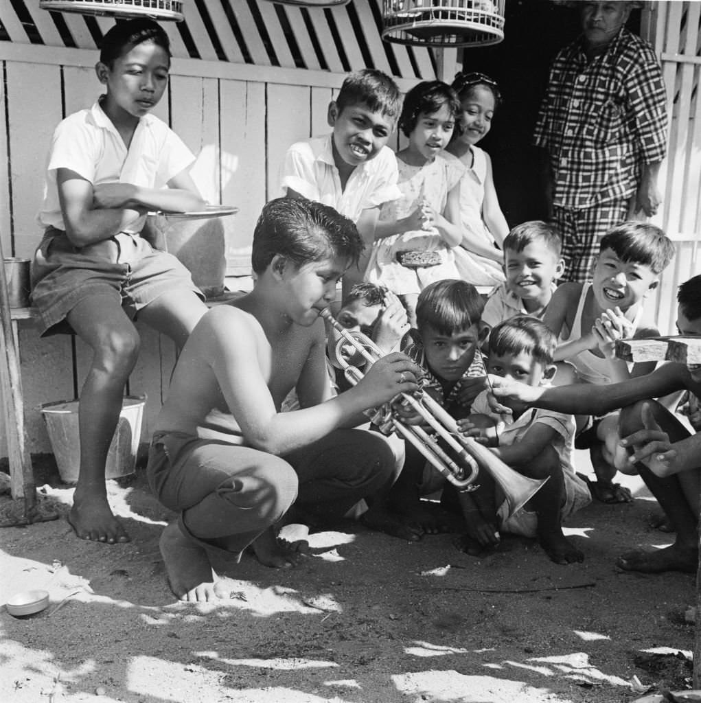 A 13 year old Antonio Castillo Jnr the son of jazz musician Don Castillo, entertains his friends with a tune on the trumpet that was a birthday gift from his father, 1960