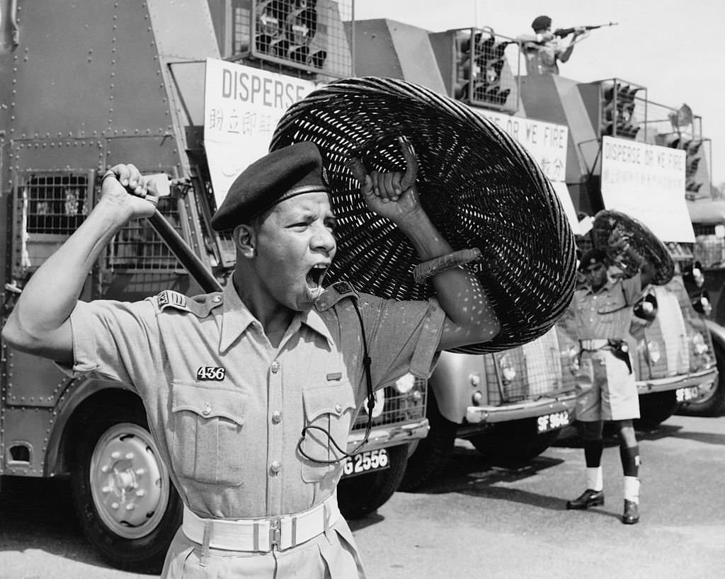 Members of the Singapore Police Riot Squad armed with truncheons and wicker riot shields during race riots between Chinese and Malay groups in Singapore, 1964.