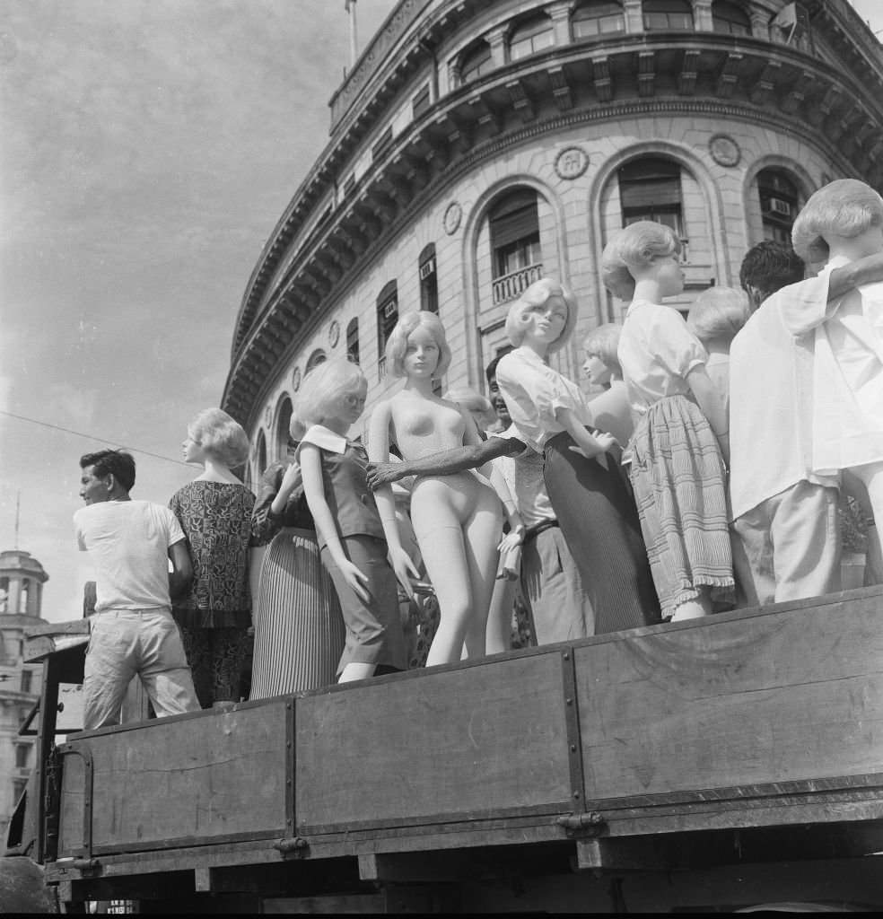 A truck load of dummies as the driver makes his way through the traffic in the heat of the morning sun on its way to the fine Asia Insurance building, 1962