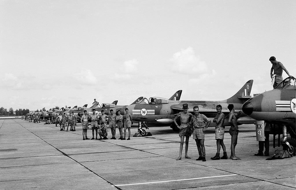 RAF Number 20 Squadron with 12 Hunter Mk 9 fighter jet aircraft pictured at their base with ground crew personal by each plane, Singapore, 1962