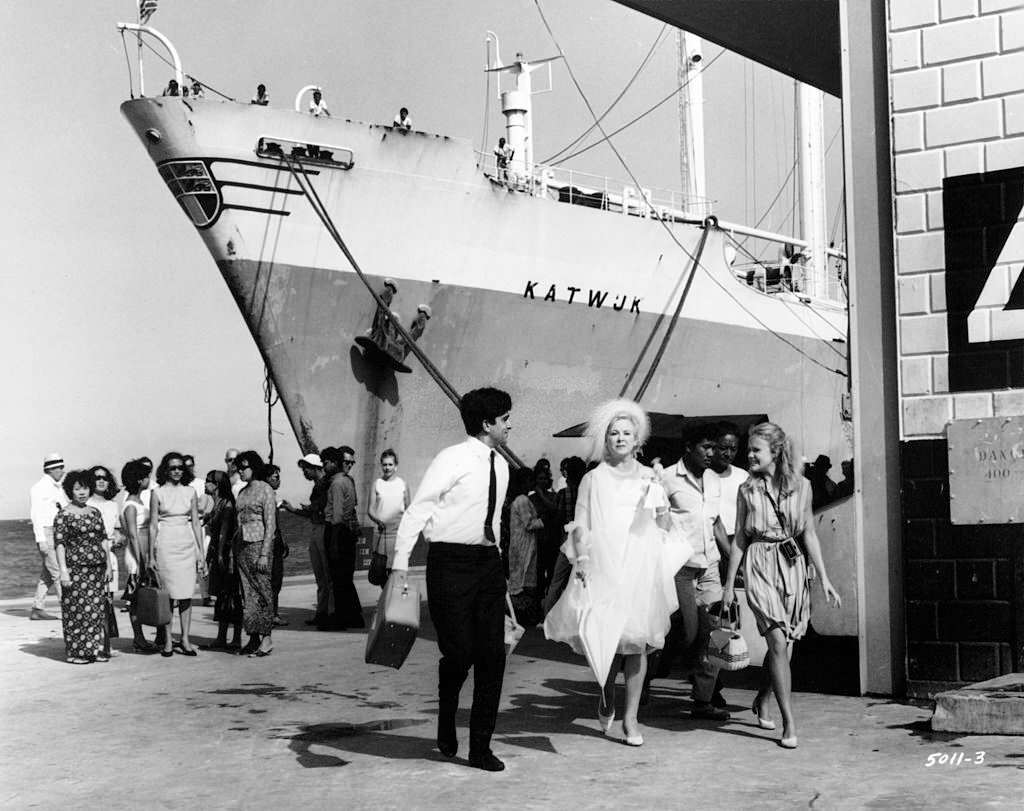 As Brenda de Banzie and Hayley Mills disembark from a cruise ship at Singapore, they are met by Shashi Kapoor in a scene from the film 'A Matter Of Innocence', 1967.