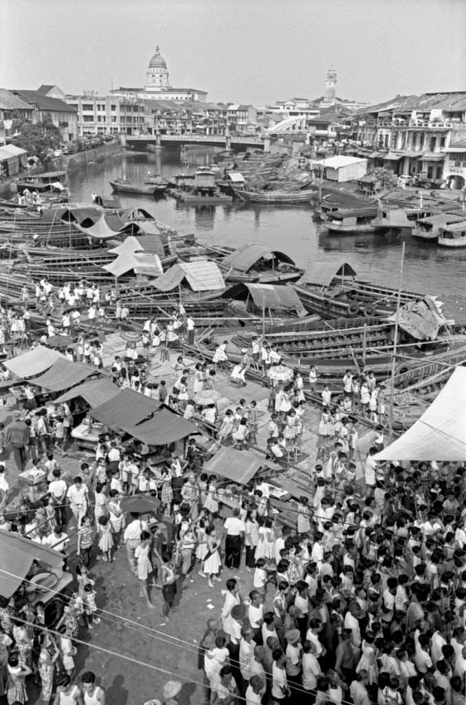 People crowding an outdoor market. Singapore, 1962