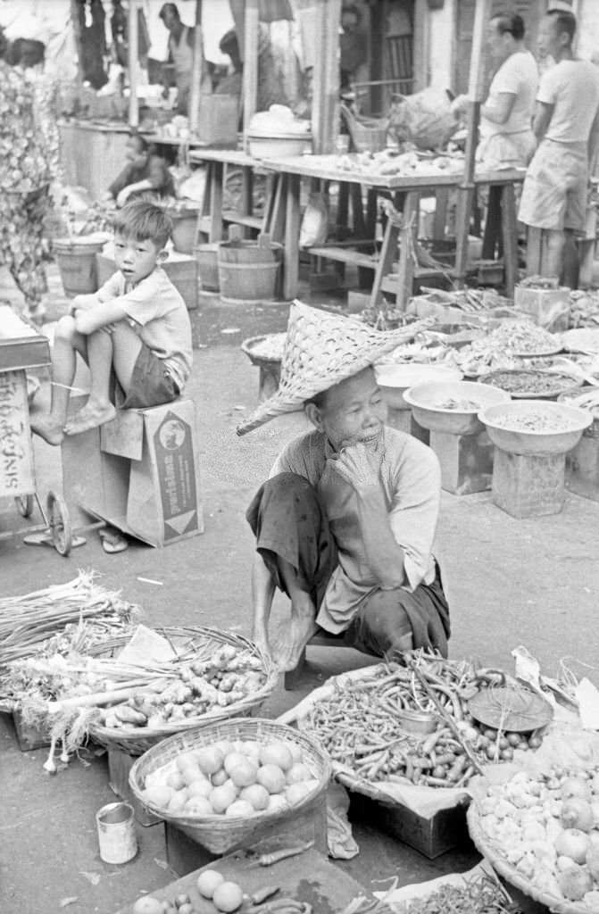 Street vendor displaying his goods in an outdoor food market, Singapore, 1962