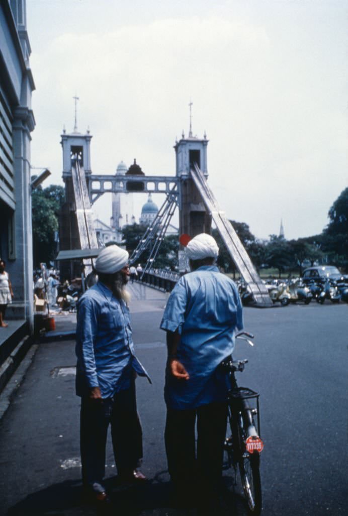 Two men with turban chatting in the street, Singapore, 1962