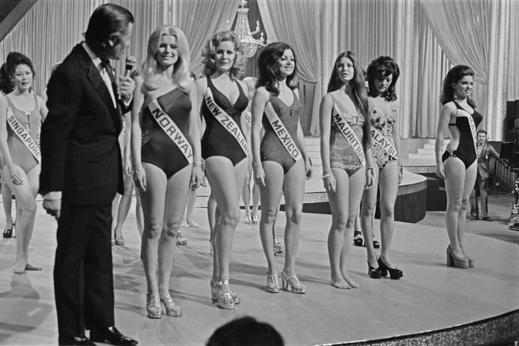 British television host Eric Morley meets some of the contestants in the Miss World 1972 beauty pageant in London.