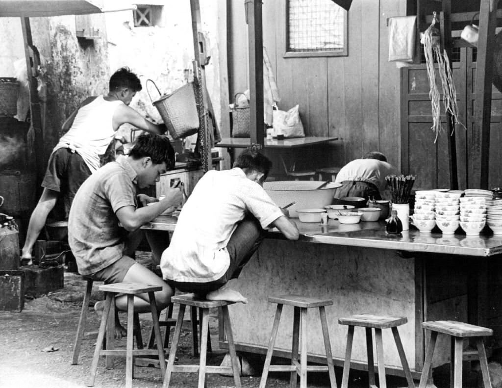 Contrast is a hallmark of Pacific travel. This is a sidewalk cafe in the teeming Chinese area of Singapore, 1971