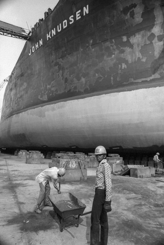 Workers in front of the liner "John Knudsen" in dry dock at a Singapore shipyard, July 1974.