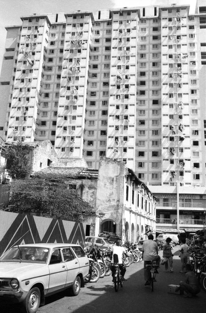 Derelict shophouses on Spring St prior to demolition face the high-rise Kreta Ayer Complex Chinatown, Singapore, 12 July 1983.