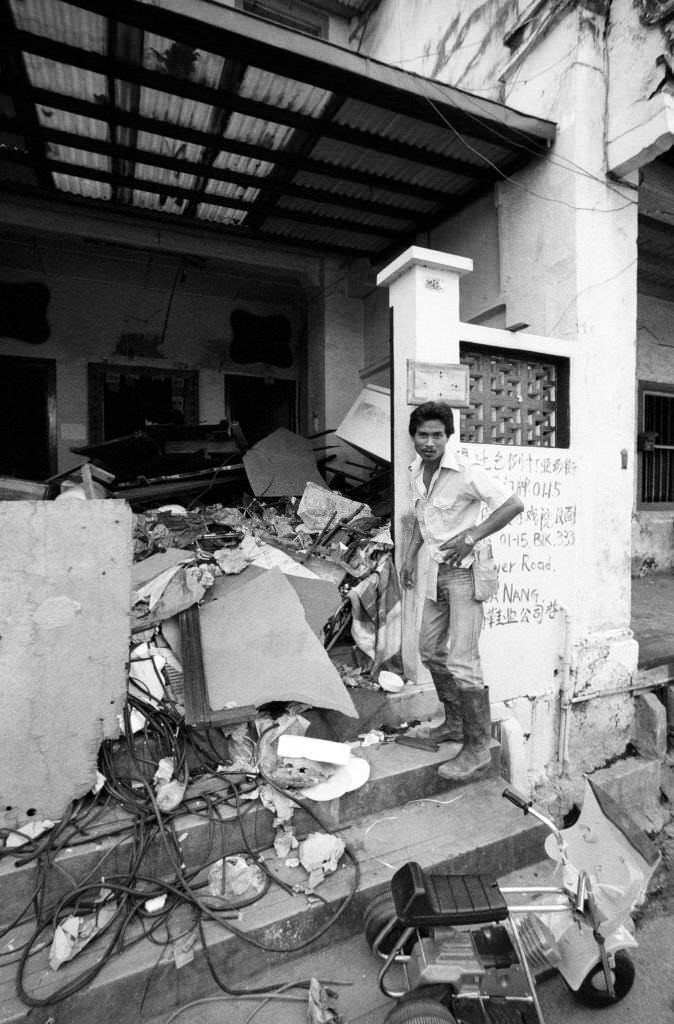 Government worker checks that this Craig Rd shophouse is vacant before demolition begins, Chinatown, Singapore, 1983