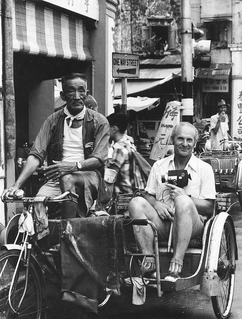 Tourist with a film camera in a cycle rickshaw in Singapore, 1980s