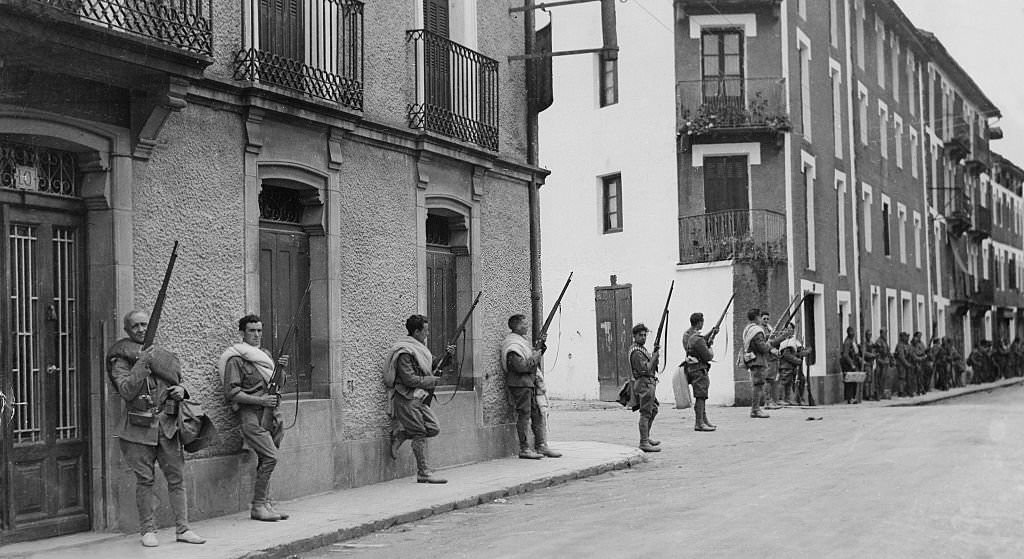 Spanish Civil War Nationalist soldiers defending a street against attacks from the roofs after they captured the town, 1936