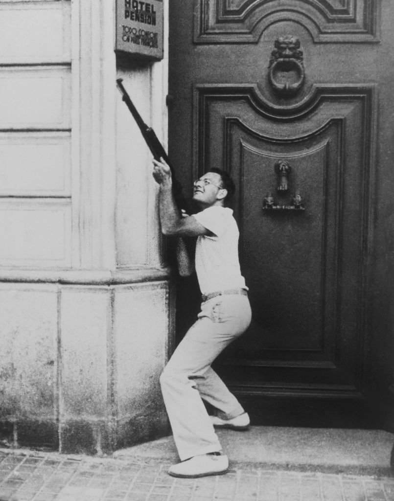 A civilian, armed by the Government, shooting from a doorway in a Barcelona street during the Spanish Civil War, July 22nd, 1936
