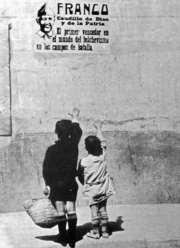 Children salute General Franco on a wall poster in Spain, during the Spanish Civil War, 1937.