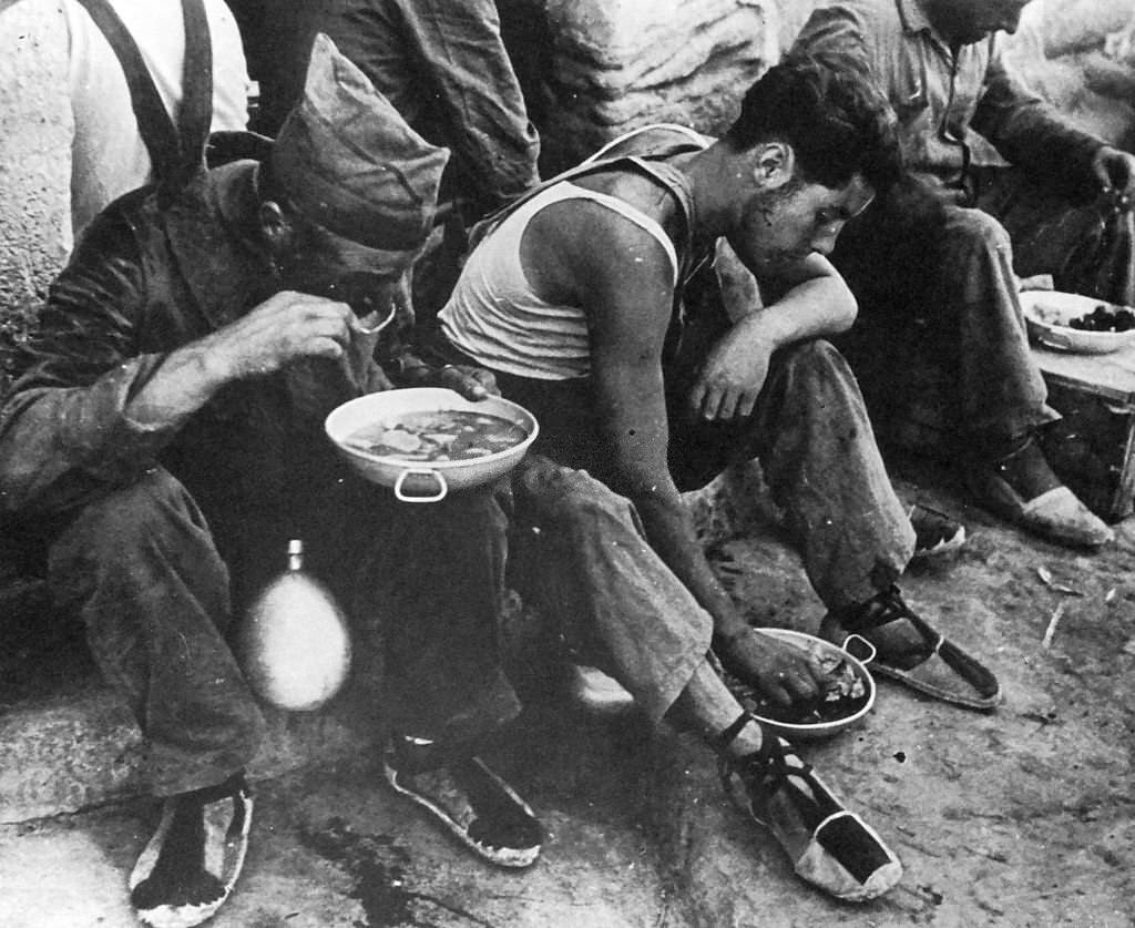 Republican soldiers rest for food, during the Spanish Civil War.
