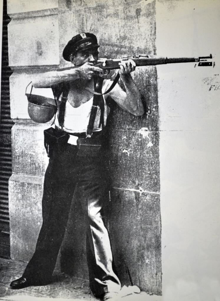 A republican marksman soldier takes shelter behind a street corner during the Spanish civil war, Barcelona 1936.