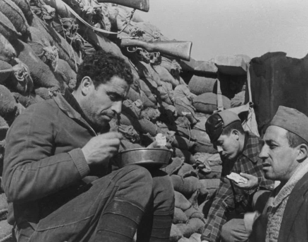 Government troops have a meal in their front line trench during the Spanish Civil War.