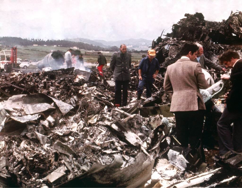 Emergency workers sift through the wreckage of the two Boeing 747s which collided on the runway, killing 583 people