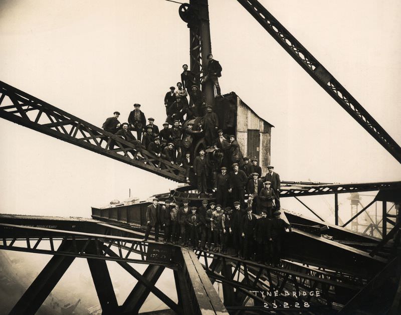 Steel erectors, riveters and crane drivers perch on a 20-ton capacity crane to mark the completion of the Tyne Bridge arch, February 23, 1928