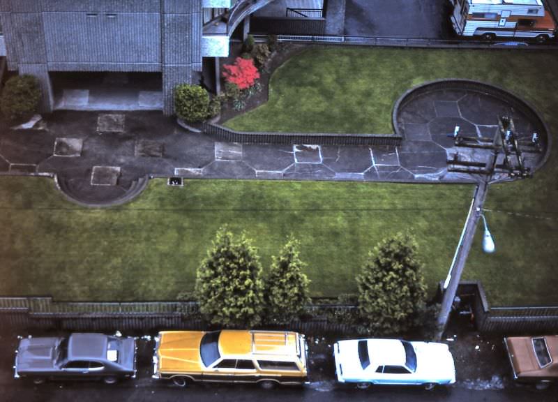View of back laneway parking and apartment building lawn as seen from Burnaby Street apartment, Vancouver, 1982