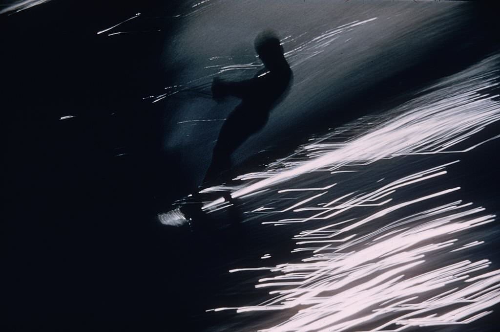 Light glints off the spray as a water-skier skims through Cypress Gardens, Florida, 1957