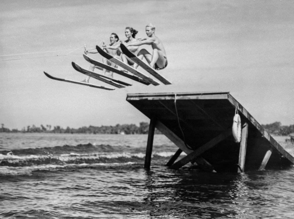 Trammel Pickett, Martha Mitchell and Dickie Rowe go up and over the high jum while tuning up the tournament, in the 1930s