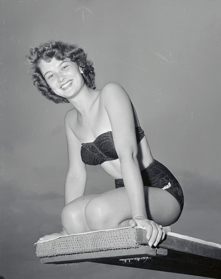 Lovely Joan Faye Binette of New Hampshire, who has been named "Miss Diving Girl of 1956" is shown perched atop a diving bard at Cypress Gardens.