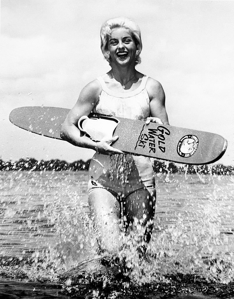 Splashing out of the water, Barbara Cooper Clack, who just set a world's record of 102 feet to win the Women's Ski Jumping Championship, shows her support with her ski.