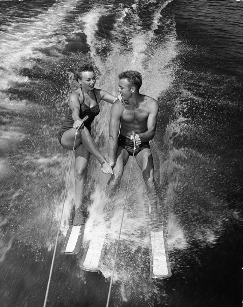 Water-ski champions Dick Pope and Jean Mason prepare to transfer from four skis to one as they speed across the course at the US Ski Centre at Cypress Gardens, 1963