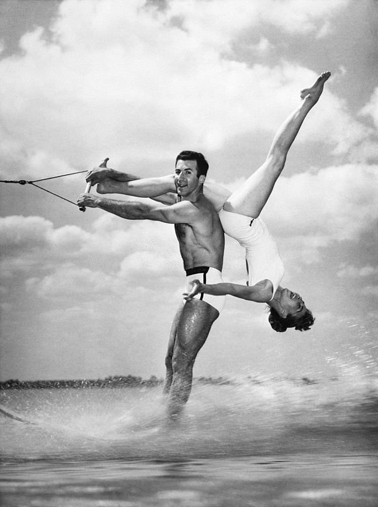 Jinx Mendoza bends over her husband Alfredo's shoulder as they perform a waterskiing exhibition at Cypress Gardens, Florida.