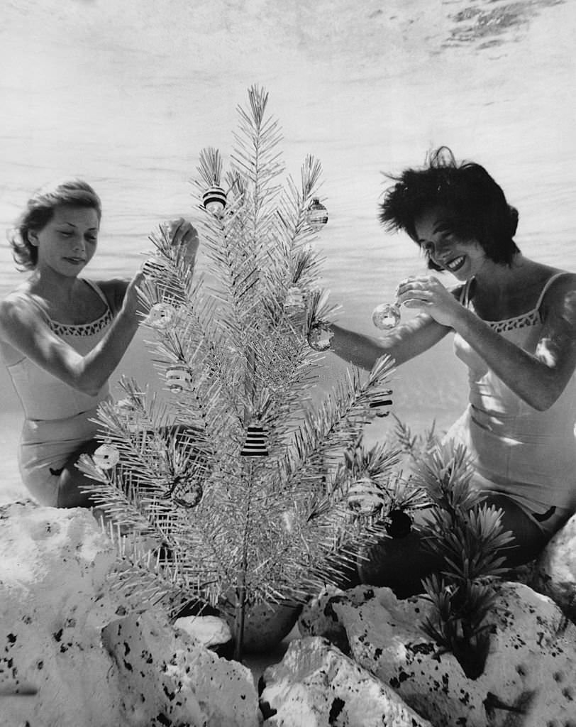 Two young women decorate a Christmas tree set up in the crystal clear waters of Cypress Gardens amusement park in Winter Haven, Florida on December 20, 1960.
