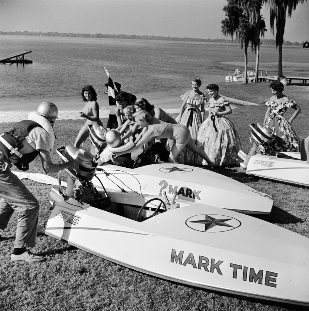 A group of female fans help the victorious speedboat racer out of his boat at the end of the Cypress Gardens racecourse, Florida, 1956