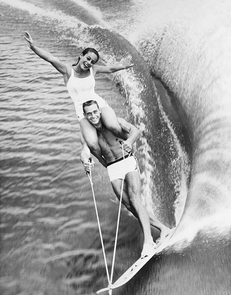 lara Marquis rides on the shoulders of fellow water skier Jim Boyd in a show at Cypress Gardens, Florida.