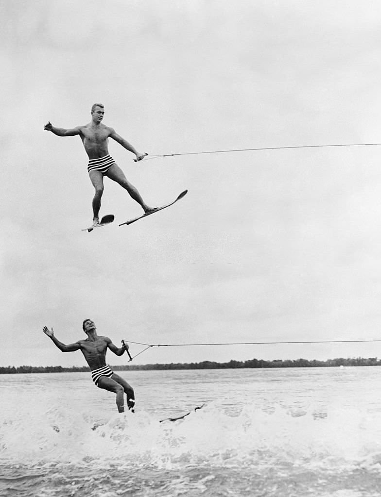 Up in the air is Jack Beatty, of Buffalo, N.Y., as he flies over Butch Rosenberg, of Cypress Gardens, in preparation for the water ski tournament to be held in May.