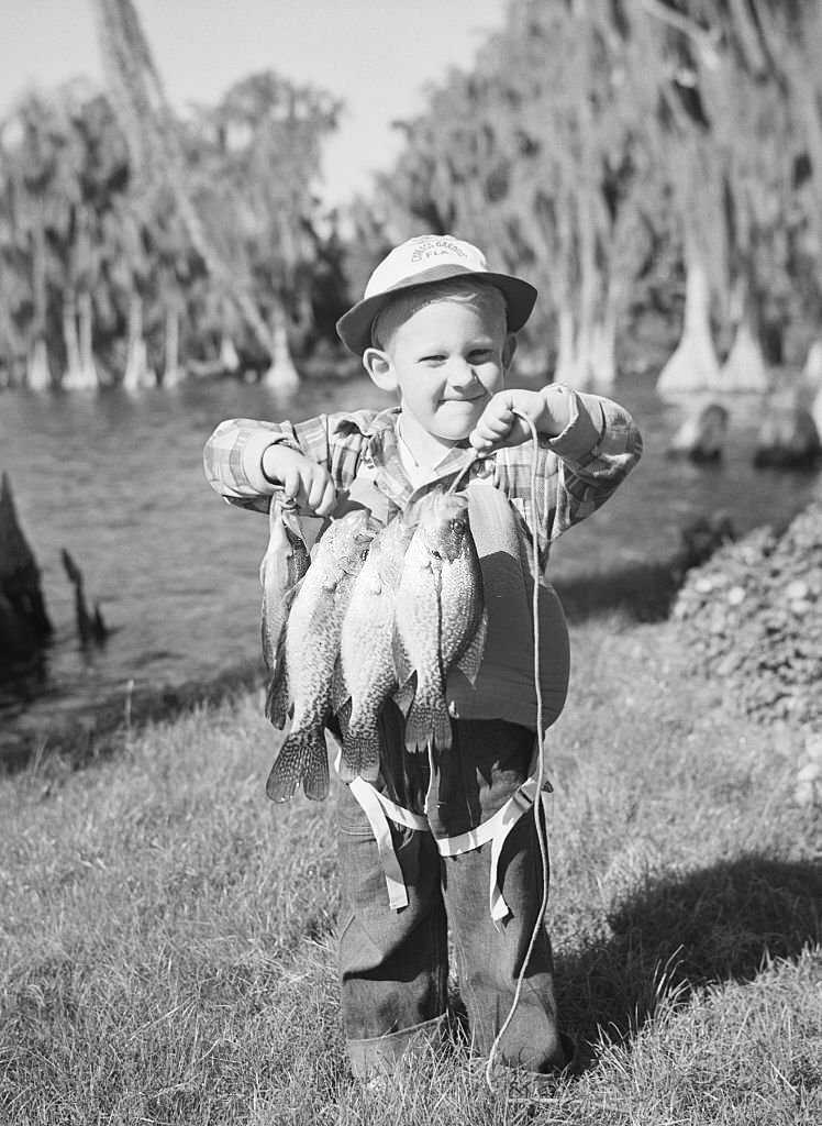 Little Terry Paulin seems to have more than his share of angler's luck. He caught this string of bass in Lake Eloise at Cypress Gardens and is all set for a fish fry.
