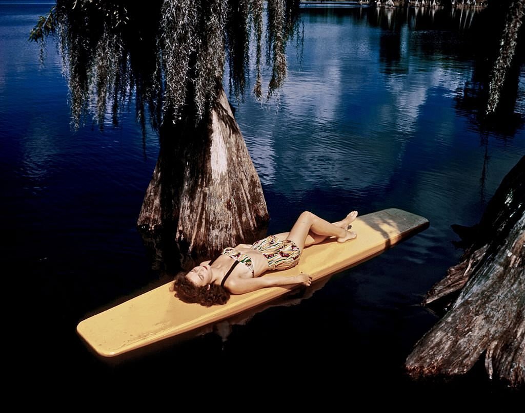 A southern belle model relaxes on a surf board between shows at Cypress Gardens theme park in 1953 near Winterhaven, Florida.