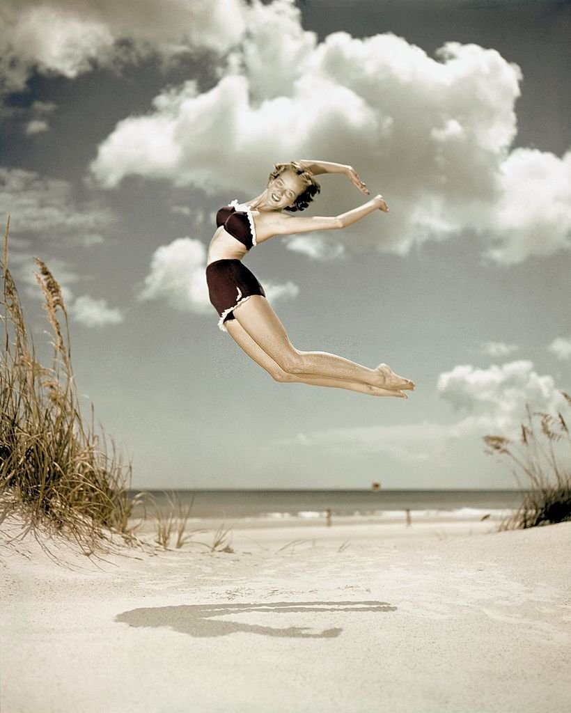 A southern belle model leaps in the air on the beach at Cypress Gardens theme park in 1953 near Winterhaven, Florida.