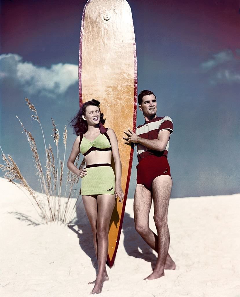 A couple of performers pose with a surf board on the beach at Cypress Gardens theme park in 1953 near Winterhaven, Florida.