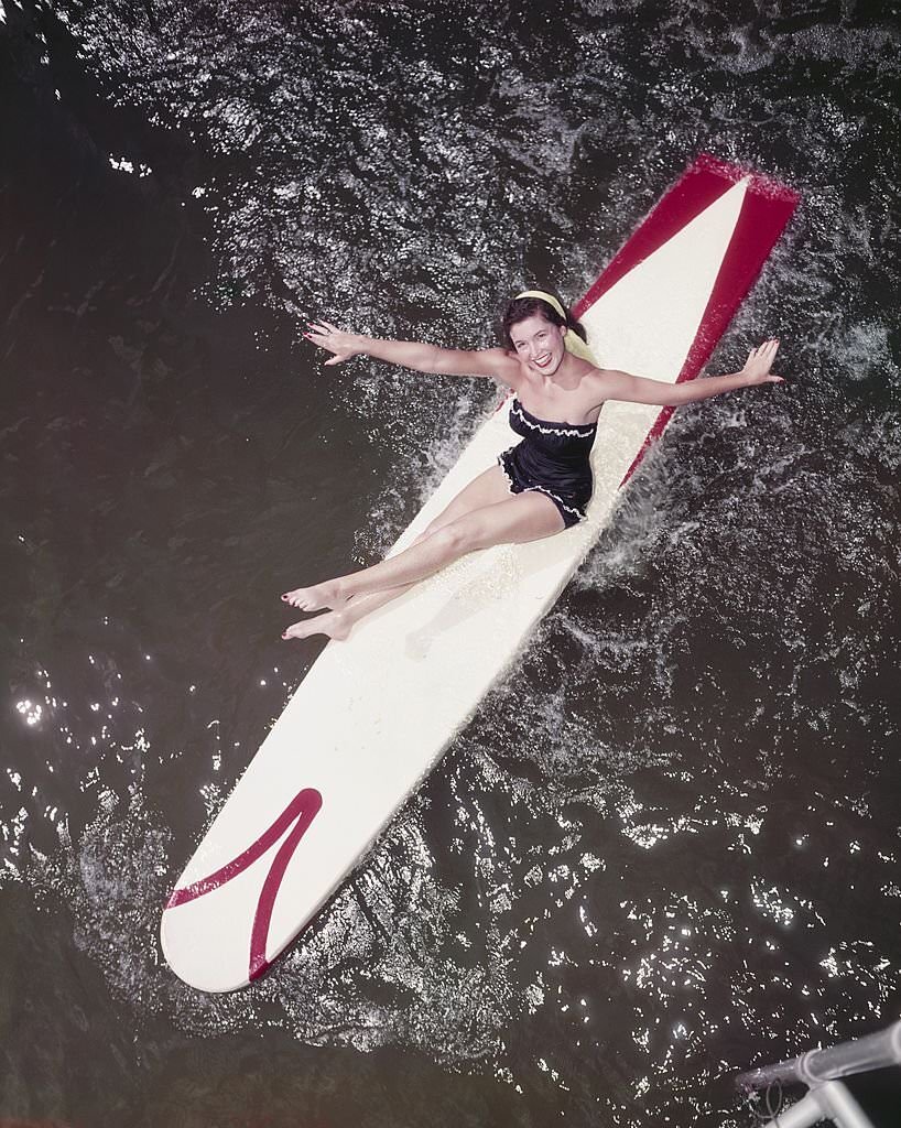 A southern belle model poses for a photo on a surf board at Cypress Gardens theme park in 1953 near Winterhaven, Florida.