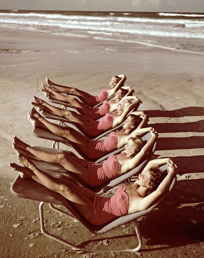A group of southern belle models sunbathe on the beach at Cypress Gardens theme park in 1953 near Winterhaven, Florida.