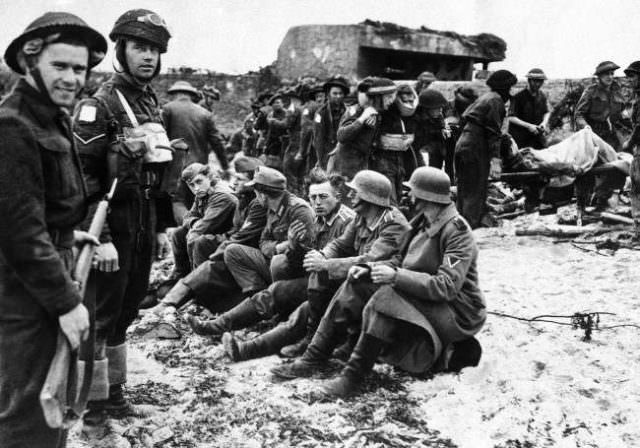 Canadian invasion troops stand guard over the first German prisoners captured during the assault on France by Allied forces on June 6, 1944 along a 100 mile front on the Normandy coast between LeHavre and Cherbourg.