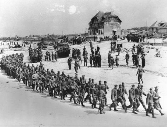 German prisoners of war, captured during the Allied Normandy invasion, are marched to the ships that bring them into captivity in England, in June 1944, at Bernieres-sur-mer, France.