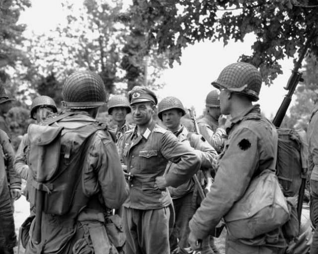 A German officer smiles as he is interrogated by American soldiers who landed on the beaches of Normandy, France on June 12, 1944.