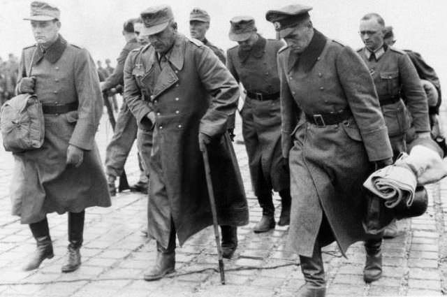 German officers, captured on the beaches of Normandy in France, hang their heads dejectedly as they arrive on June 10, 1944 in England en route to prisoner of war camps.