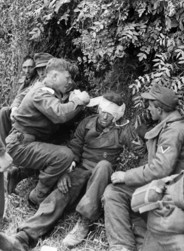 A stretcher bearer attends to a wounded German near the village of Lingevres, France on June 16, 1944, where a fierce battle was fought.