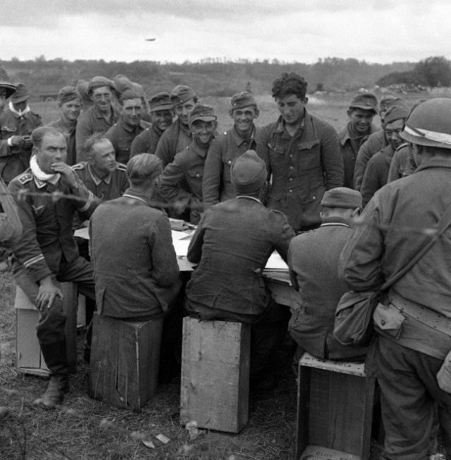German soldiers, captured by Allied Armies on the Normandy beachheads in France on June 16, 1944, are checked by fellow prisoners.